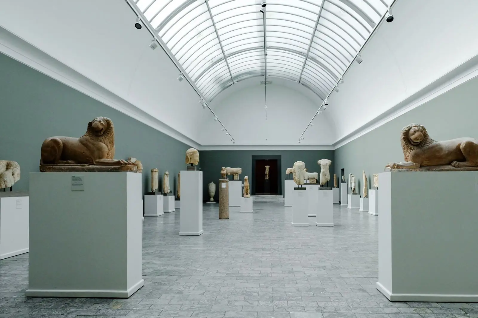 Bright contemporary gallery interior with abstract paintings and a single visitor