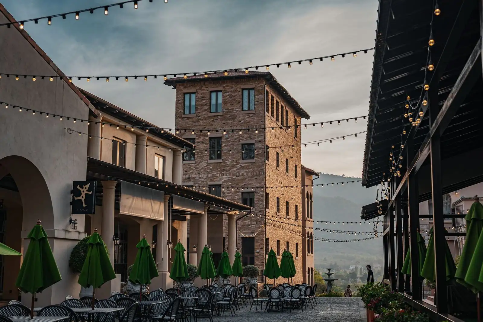 Candlelit courtyard restaurant terrace in Naples at dusk with bougainvillea and lanterns