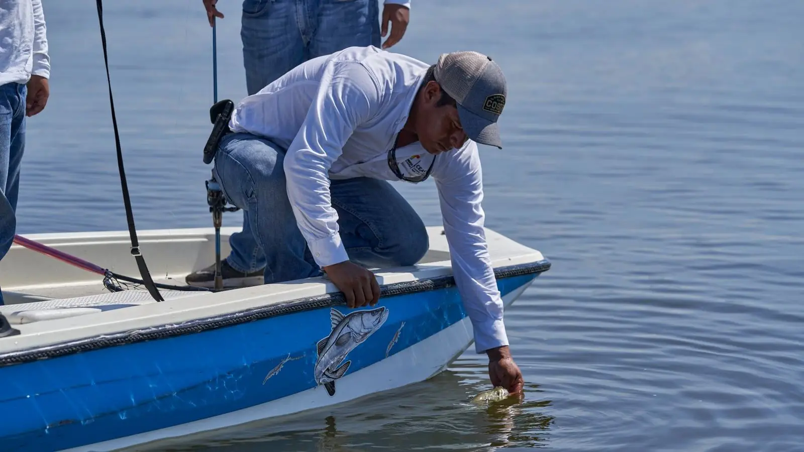 Angler casting from the bow of a small boat on calm backwater flats near mangroves in Southwest Florida